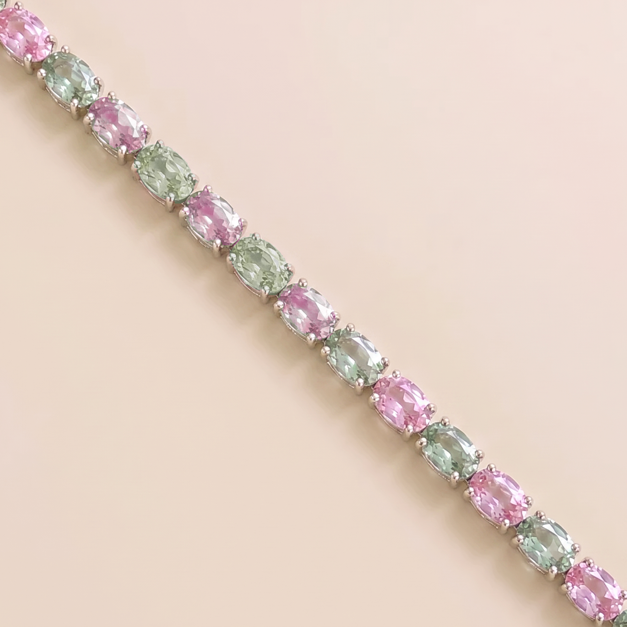 Oval lab-grown pastel pink and green sapphire tennis bracelet in white gold | Juvetti London.