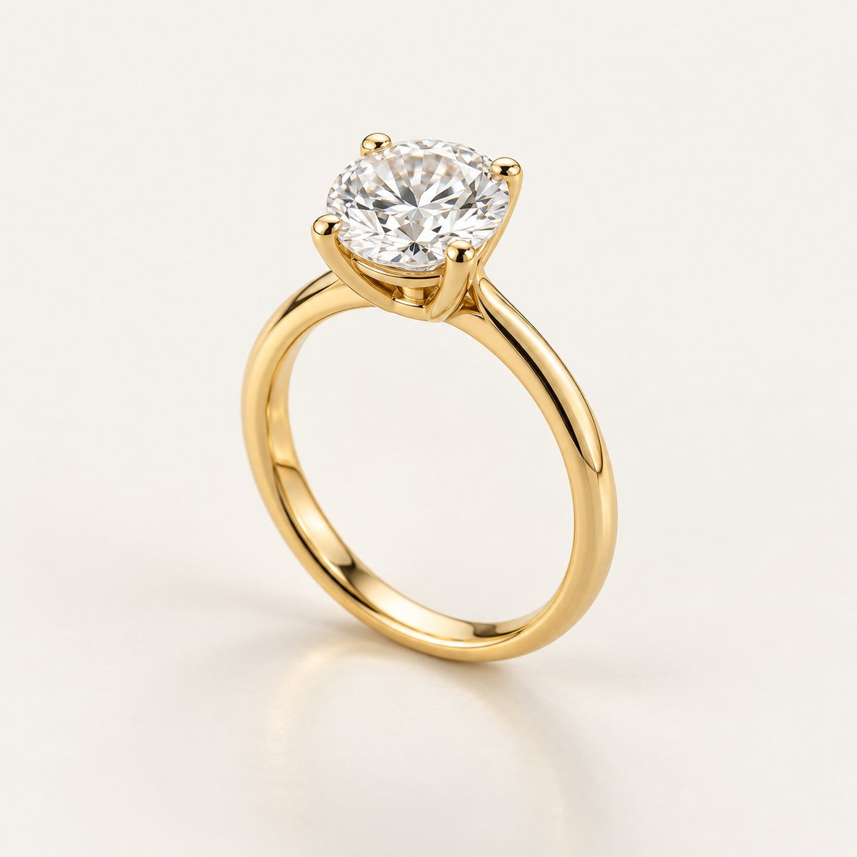 Solitaire ring setting in yellow gold with four rounded claws and a slim 2 mm band, shown with a 1 ct round diamond