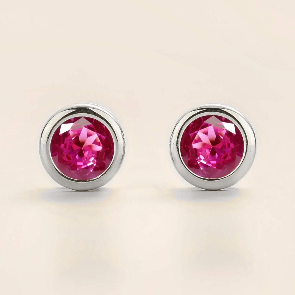Margo vivid pink sapphire round bezel set solitaire stud earrings in white gold