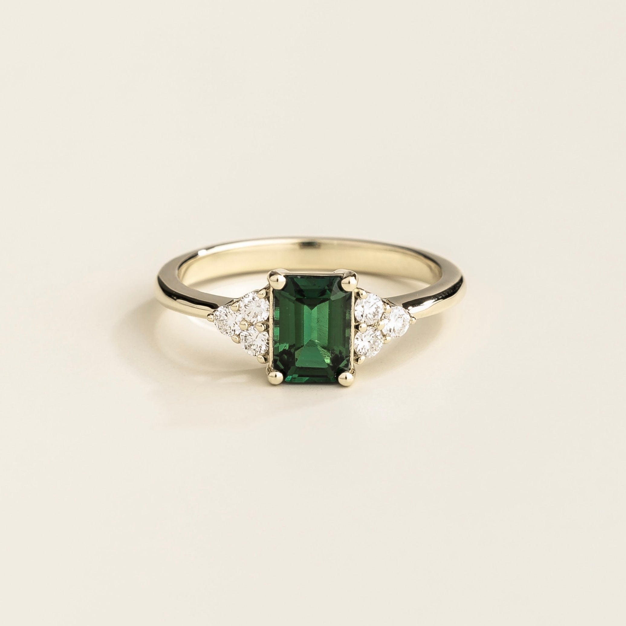 Juvetti white gold ring featuring an emerald-cut lab-grown emerald with lab-grown diamond side stones.