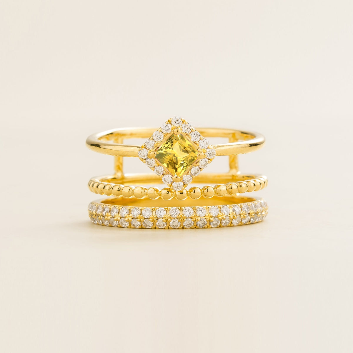 Amici triple-band stacking ring in gold, princess-cut lab-grown yellow sapphire in a diamond halo with beaded and pavé bands, front view | Juvetti London