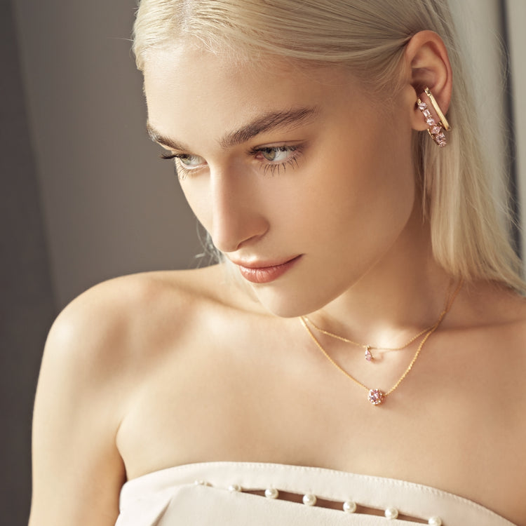 A model wearing Serene cuff earrings, hexagon Melba necklace and Ori pear drop necklace set with lan grown pink sapphire and diamond gem stones.