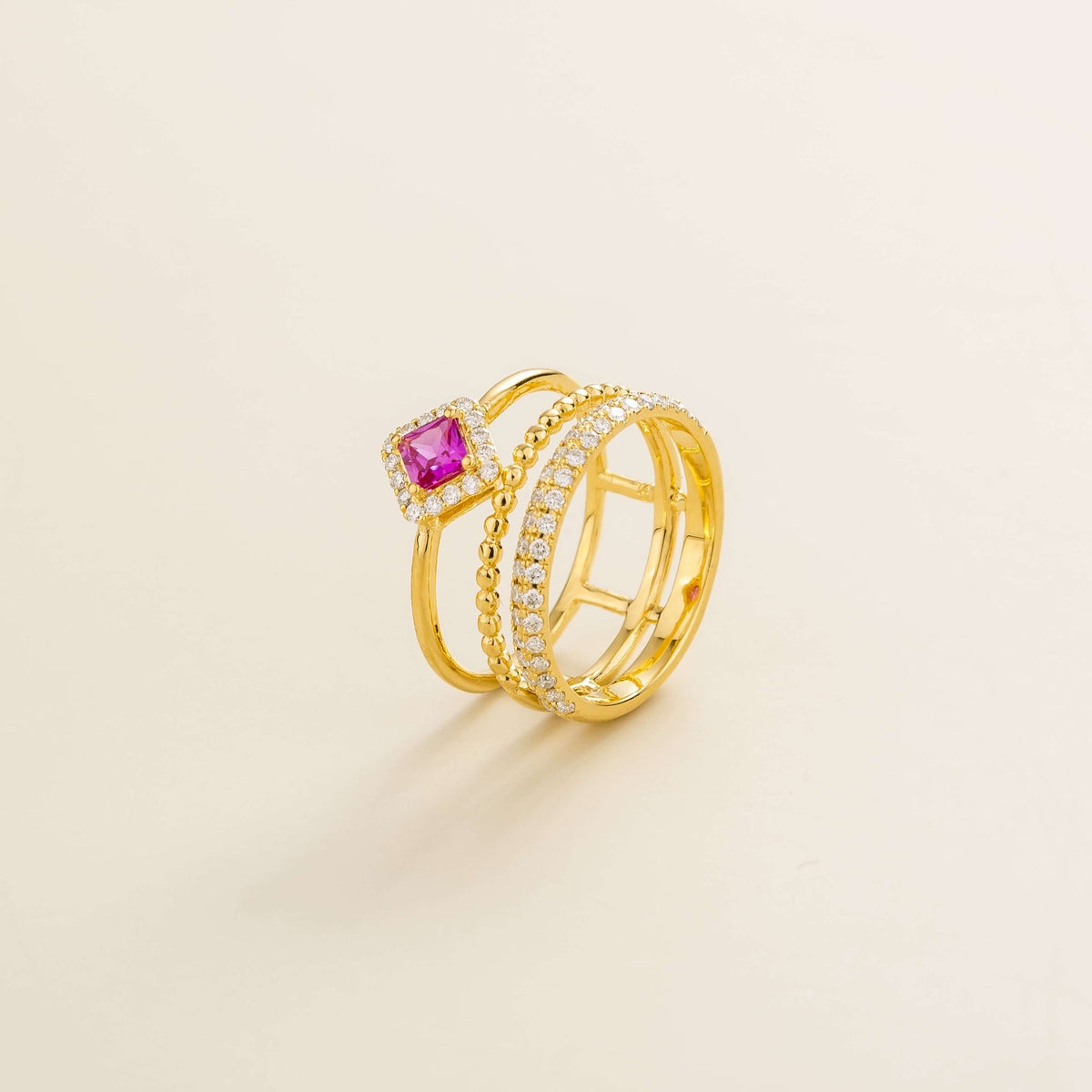 Amici triple-band stacking ring in gold, princess-cut lab-grown pink sapphire in a diamond halo with beaded and pavé bands, side view | Juvetti London